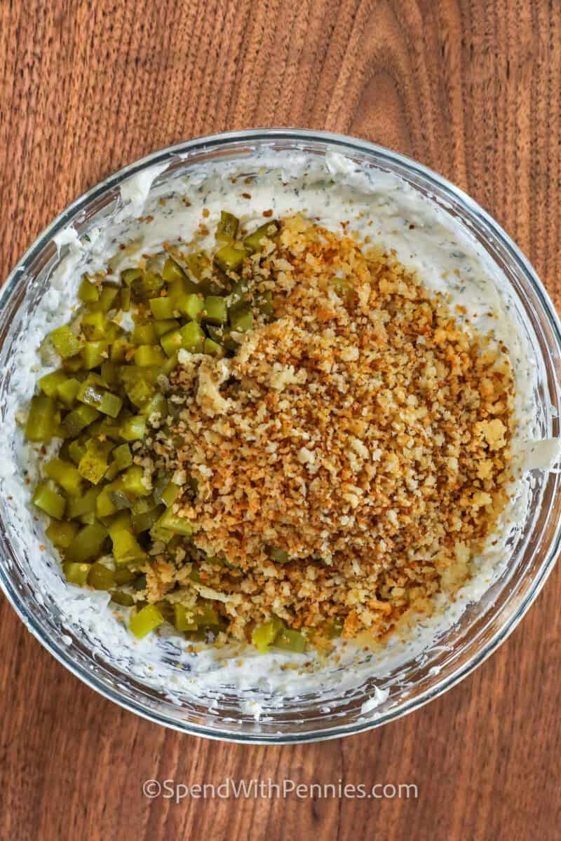 adding pickles and breadcrumbs to bowl to make Fried Pickle Dip