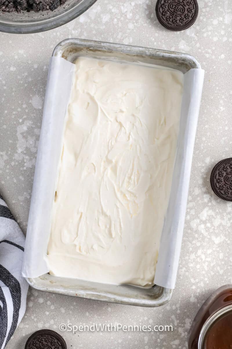 adding cool whip to pan to make Oreo Ice Cream Cake