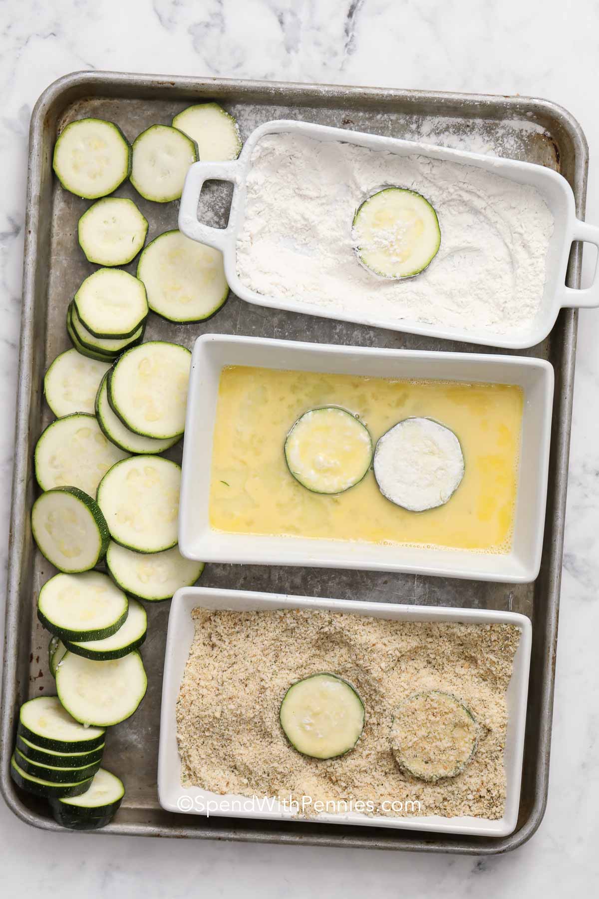 dipping zucchini in flour, egg, and breadcrumbs for frying