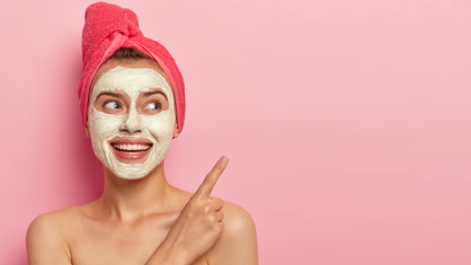 A woman with a face mask and pointing at something