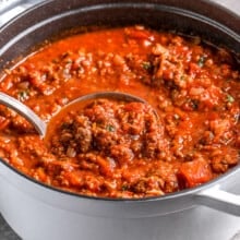 ladle scooping homemade spaghetti sauce with text