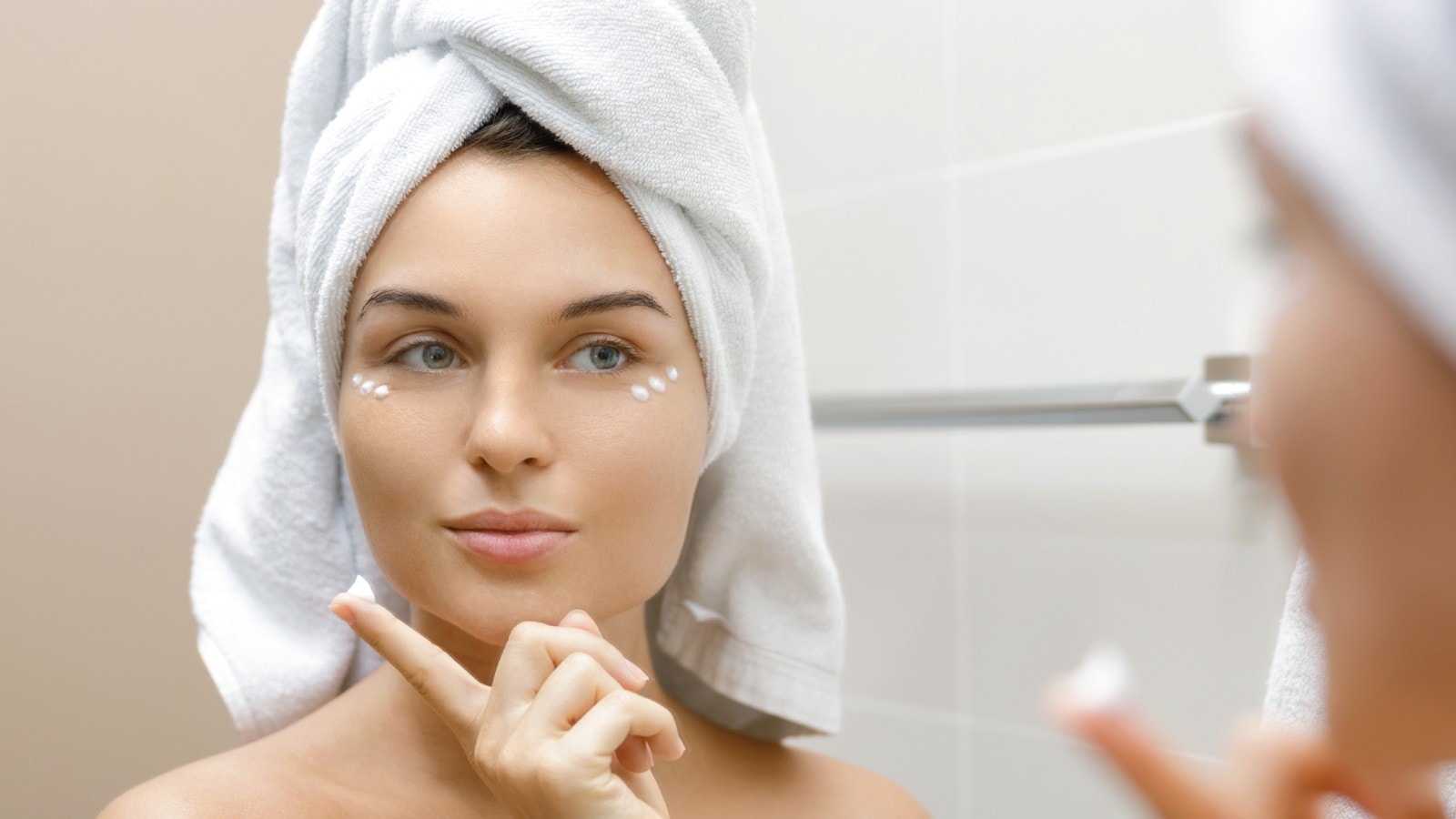 woman putting cream on face