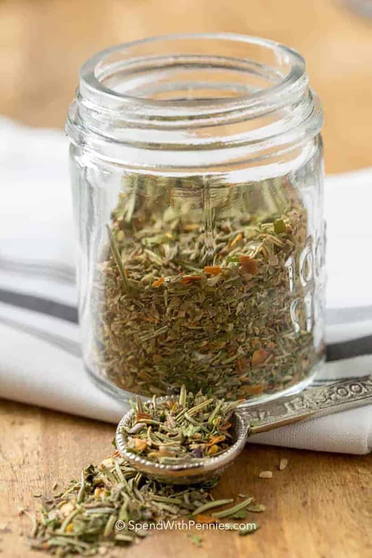 Italian Seasoning in a jar with a measuring spoon 