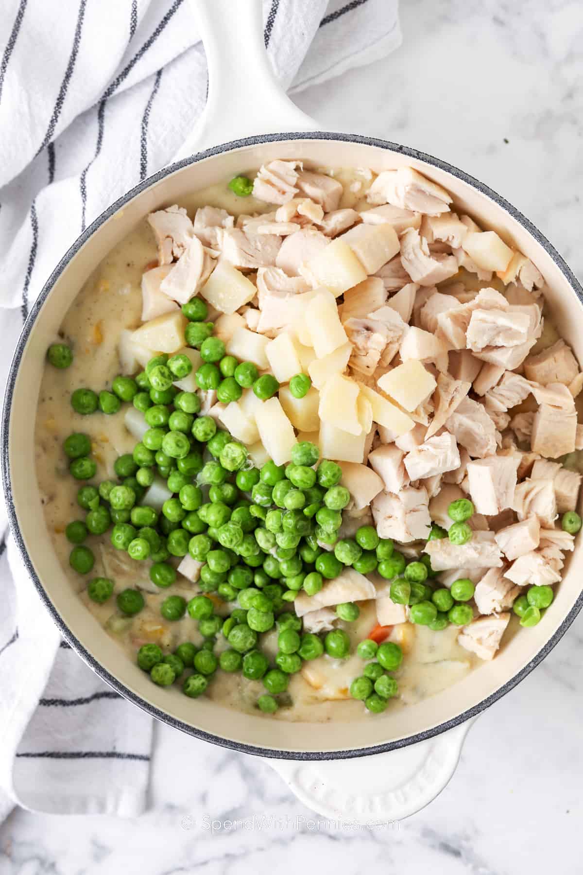 a pot with peas, chicken and potatoes