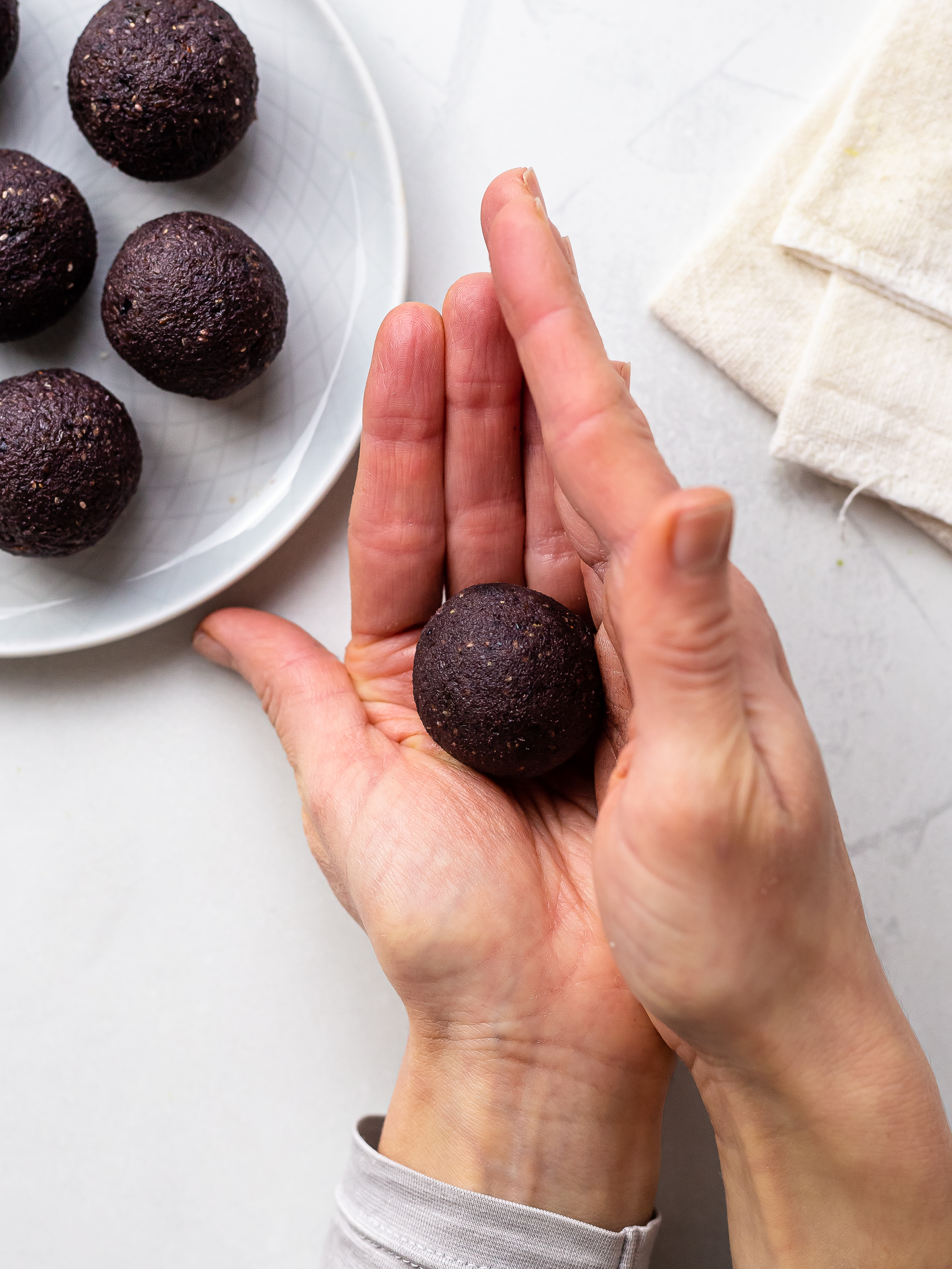 hands shaping an acai energy ball