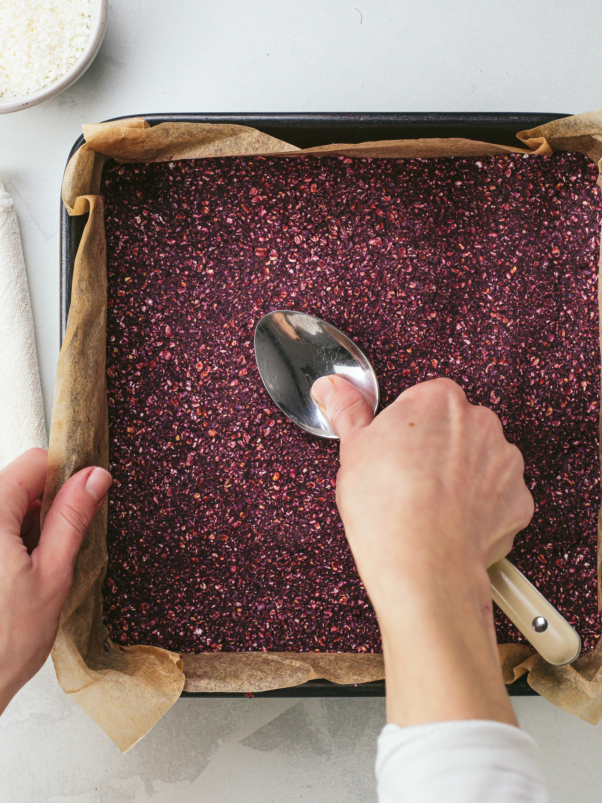 cherry flapjack dough spread into a tray and flattened with a spoon