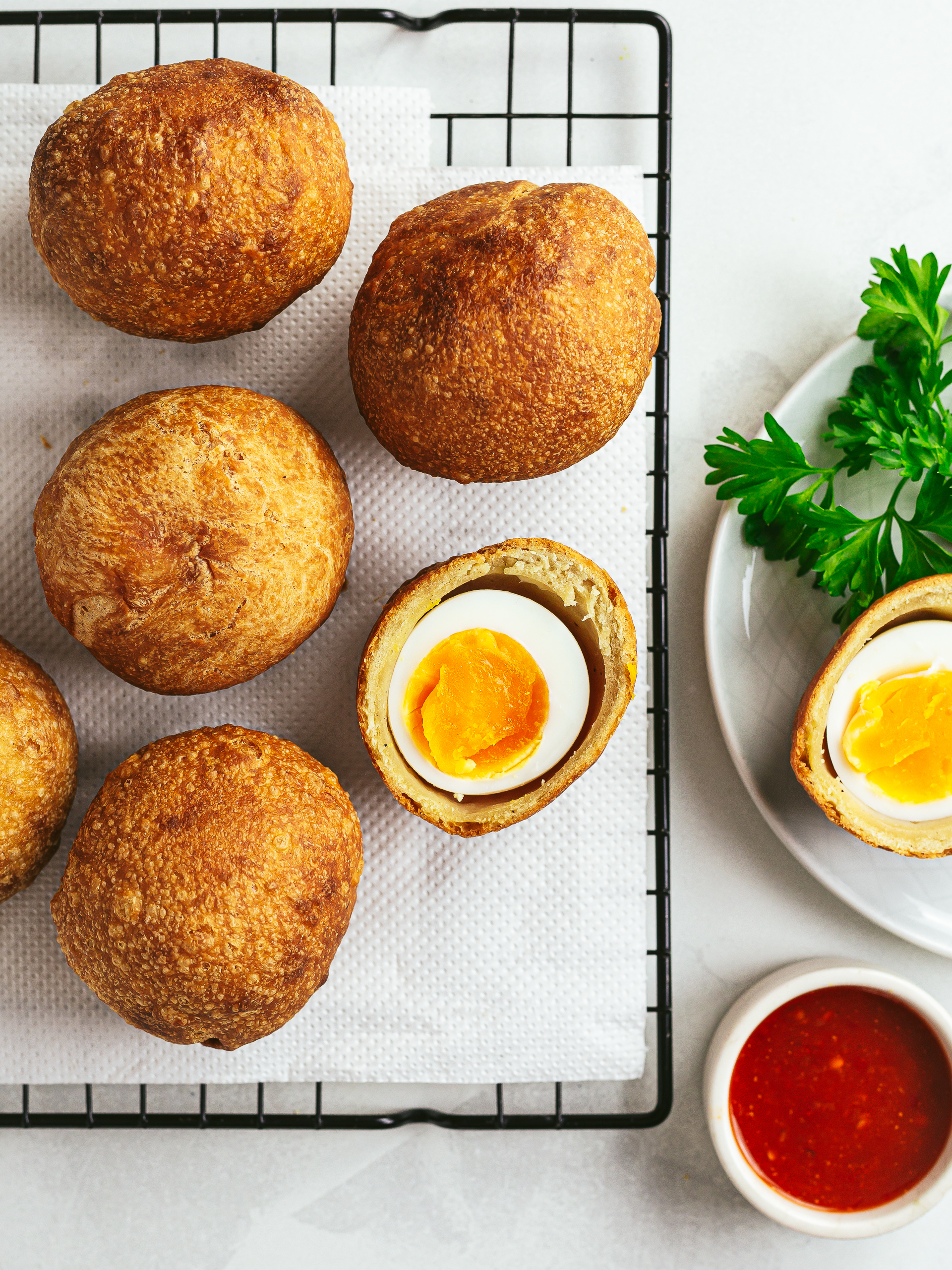 fried African egg buns on a rack with spicy sauce