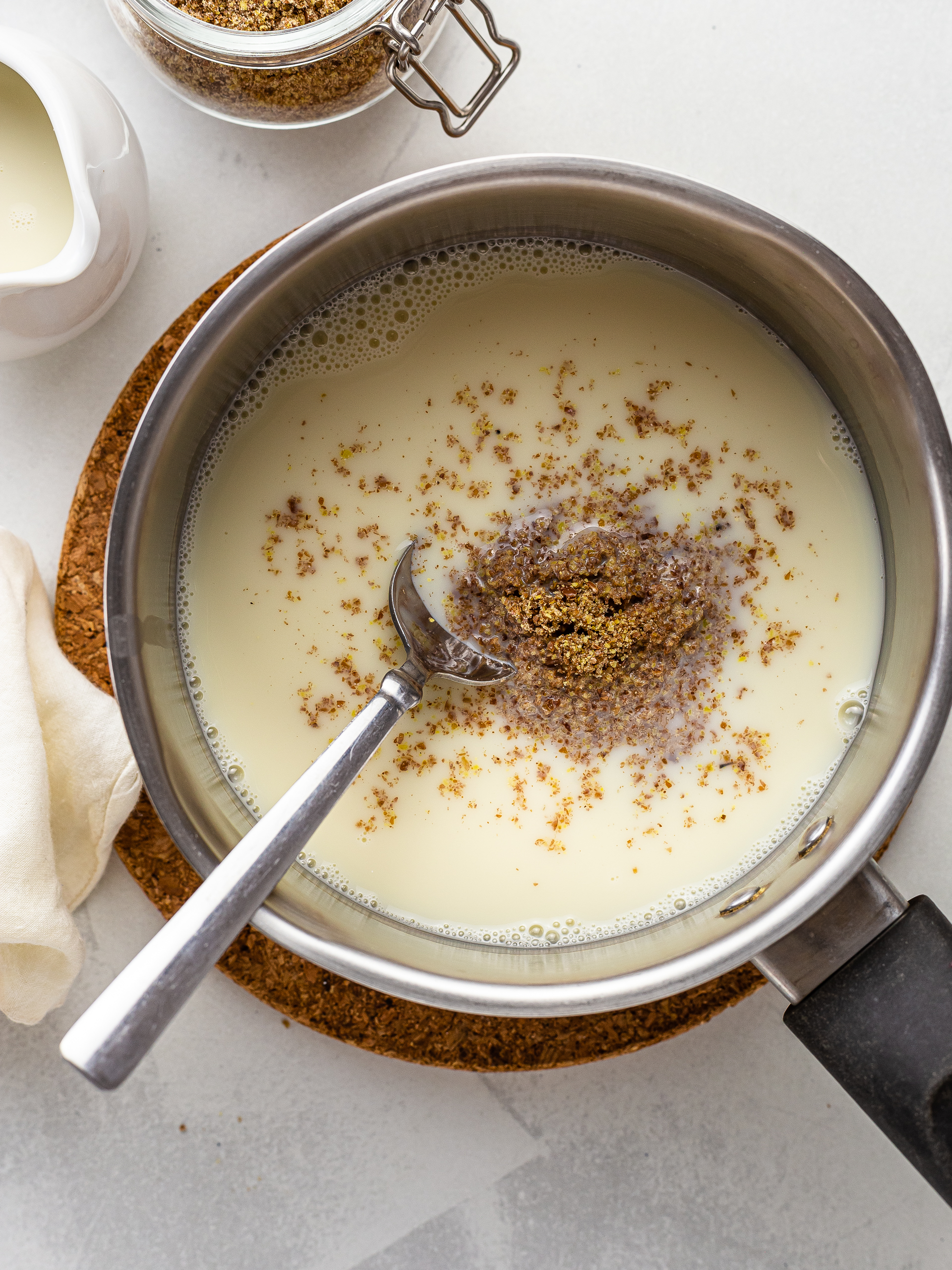 ground flaxseeds stirred into milk in a pot for porridge