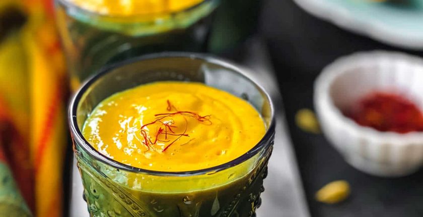 Three glasses of Mango Lassi served on a marble slab