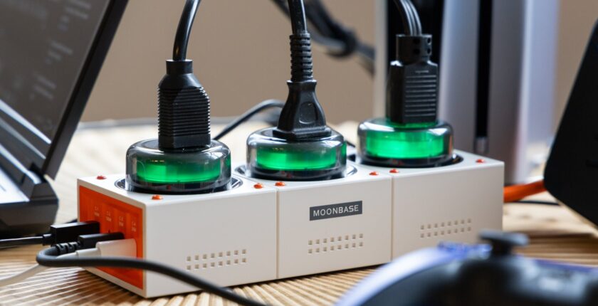 Close up Genki Moonbase Power Strip on table with the AC outlets glowing green